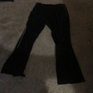 Pair of black sweatpants with grey stripes on The legs.